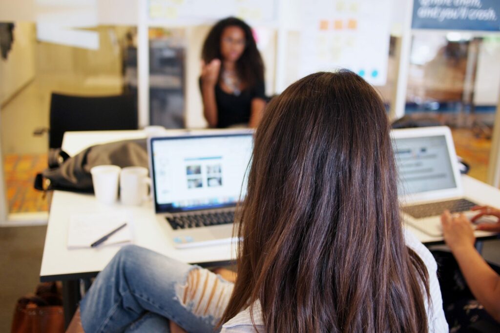 Woman sitting looking at laptop in meeting