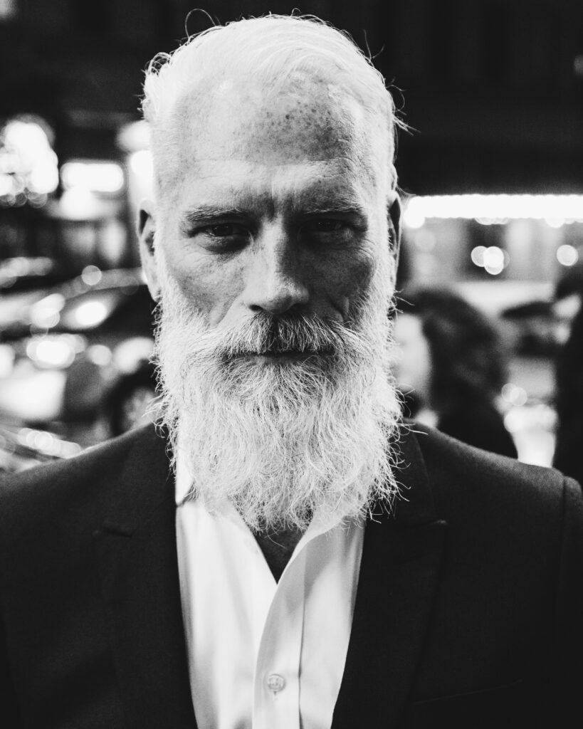older man with a long white beard wearing a suit