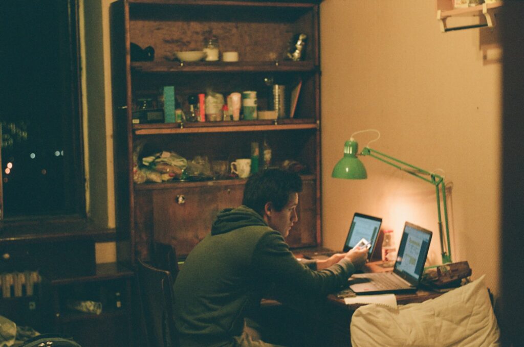 Man studying in his bedroom with a reading lamp