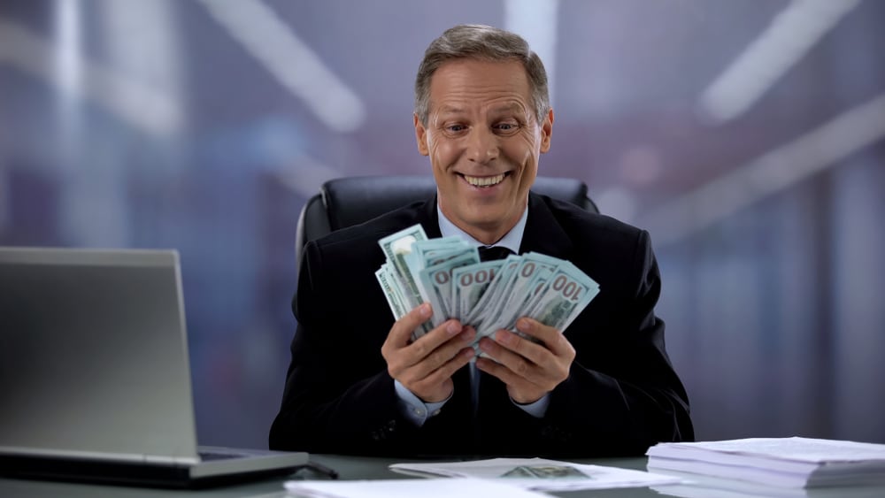 A man holding money and rejoicing