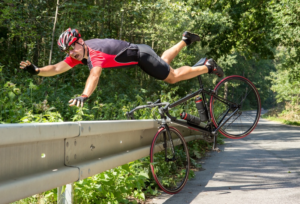 Cyclist jumping off his bike after hitting a barricade