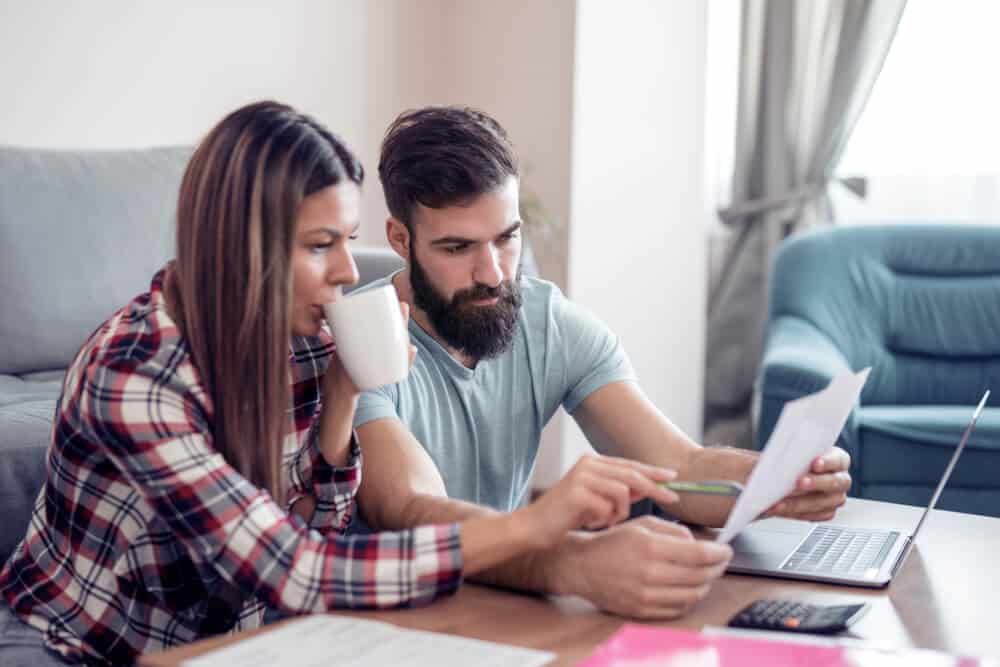 Couple working out their financial plan in the sitting room