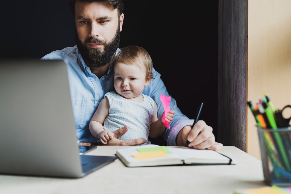 Father with baby studying online