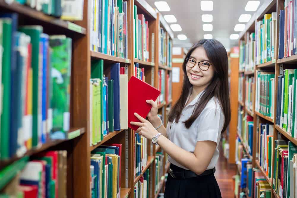 Cheerful Asian student in the library