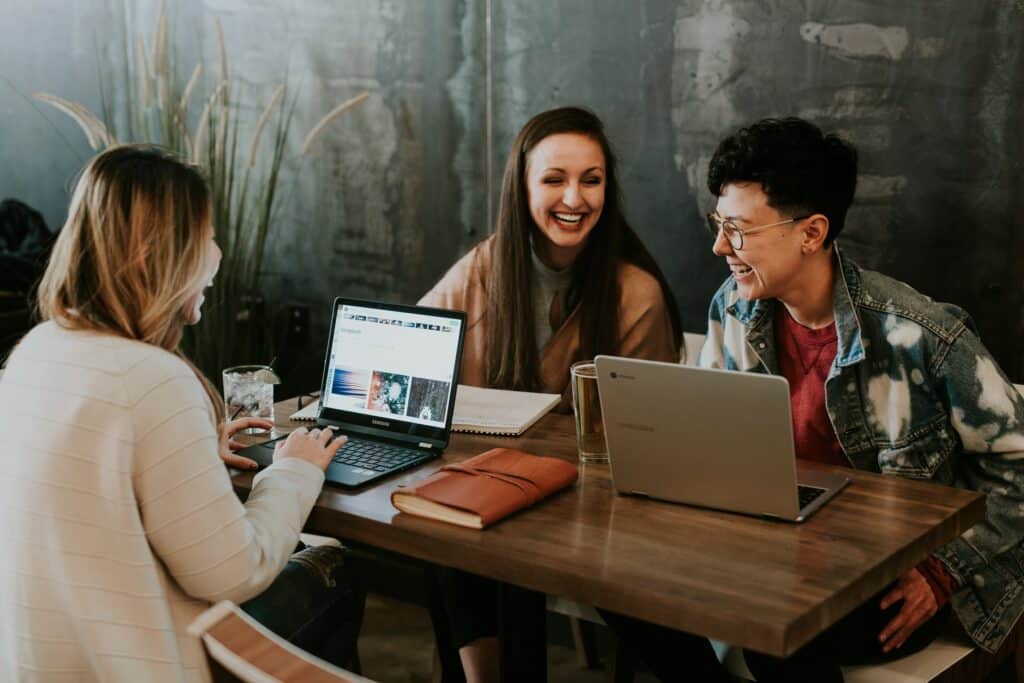 three CS interns laughing in from of their computers