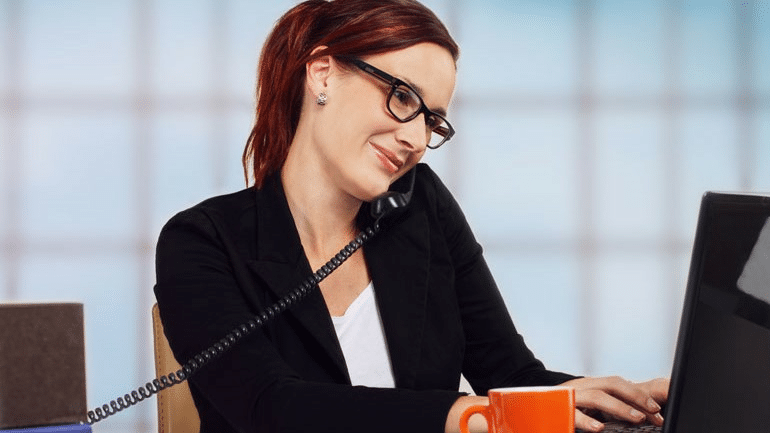 woman on the telephone while working on her office laptop