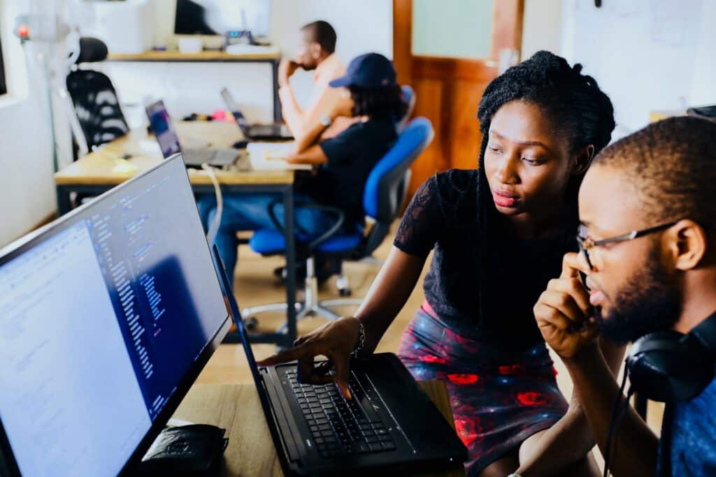 young man and woman working on a single monitor