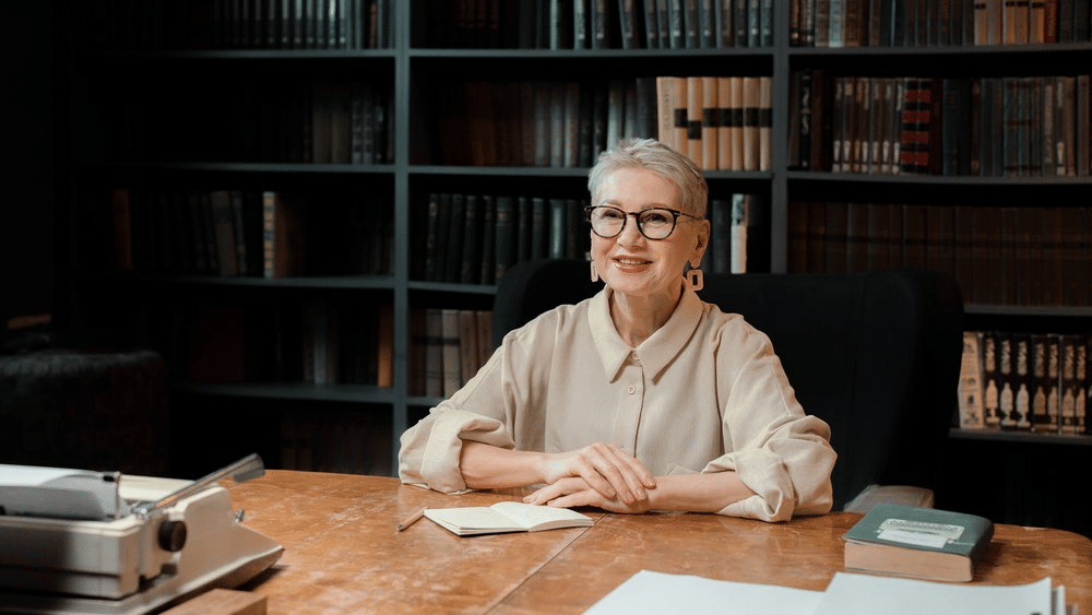 Elderly female librarian wearing glasses and smiling