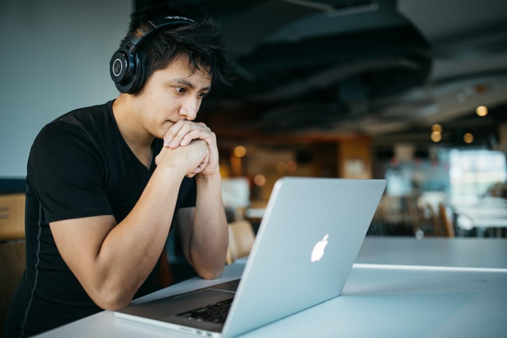 CS intern wearing headphones while using his MacBook